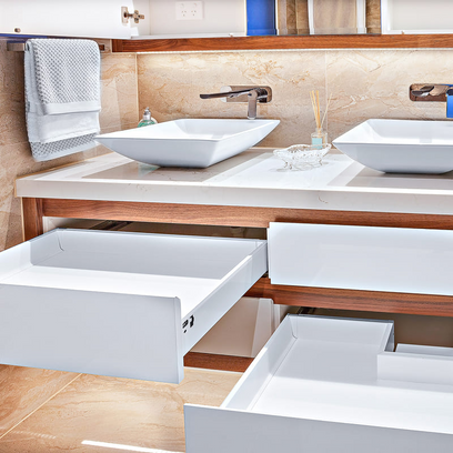 Un baño con dos lavabos y cajones abiertos.