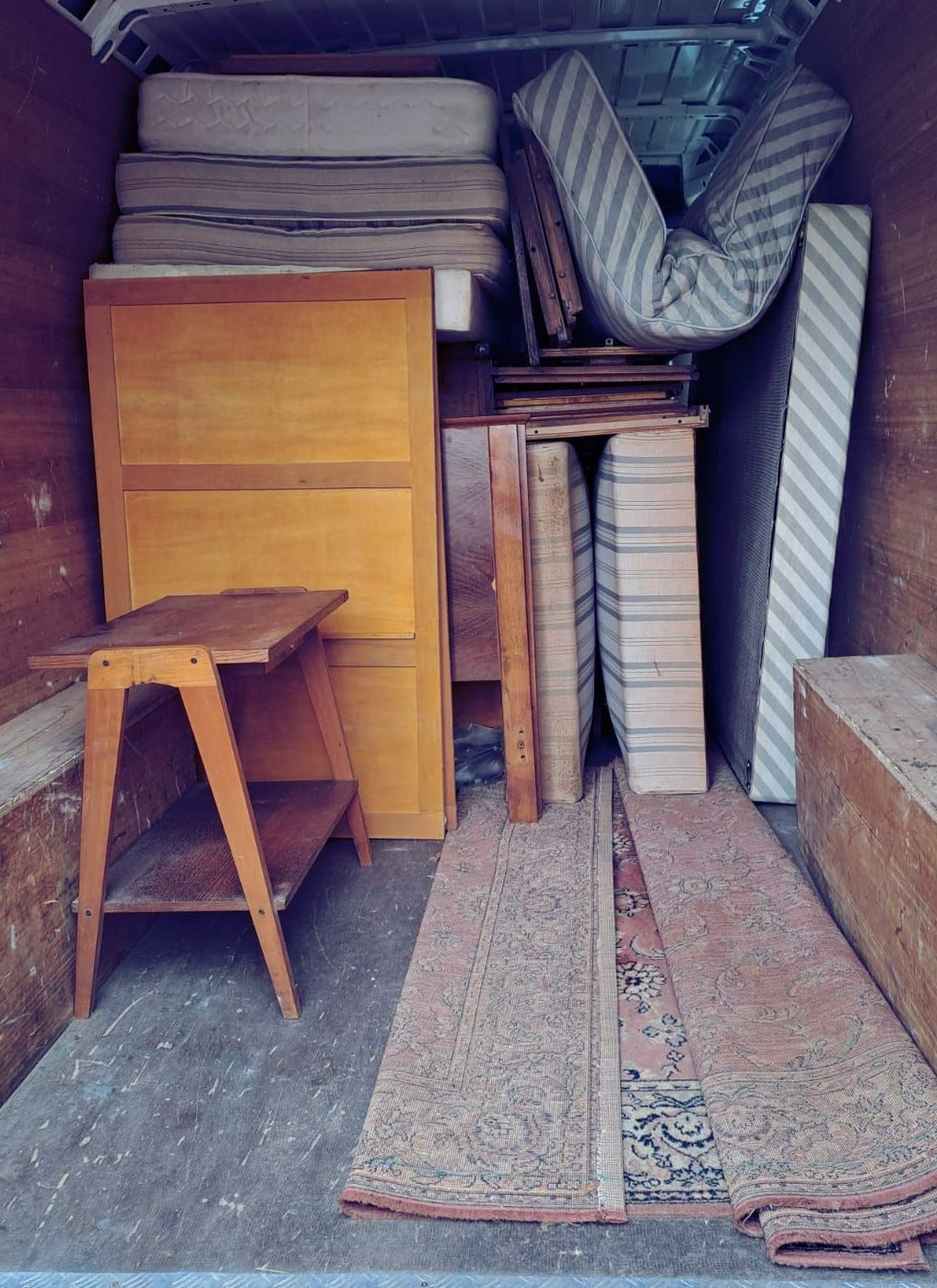 Matelas empilés dans une camionnette de débarras