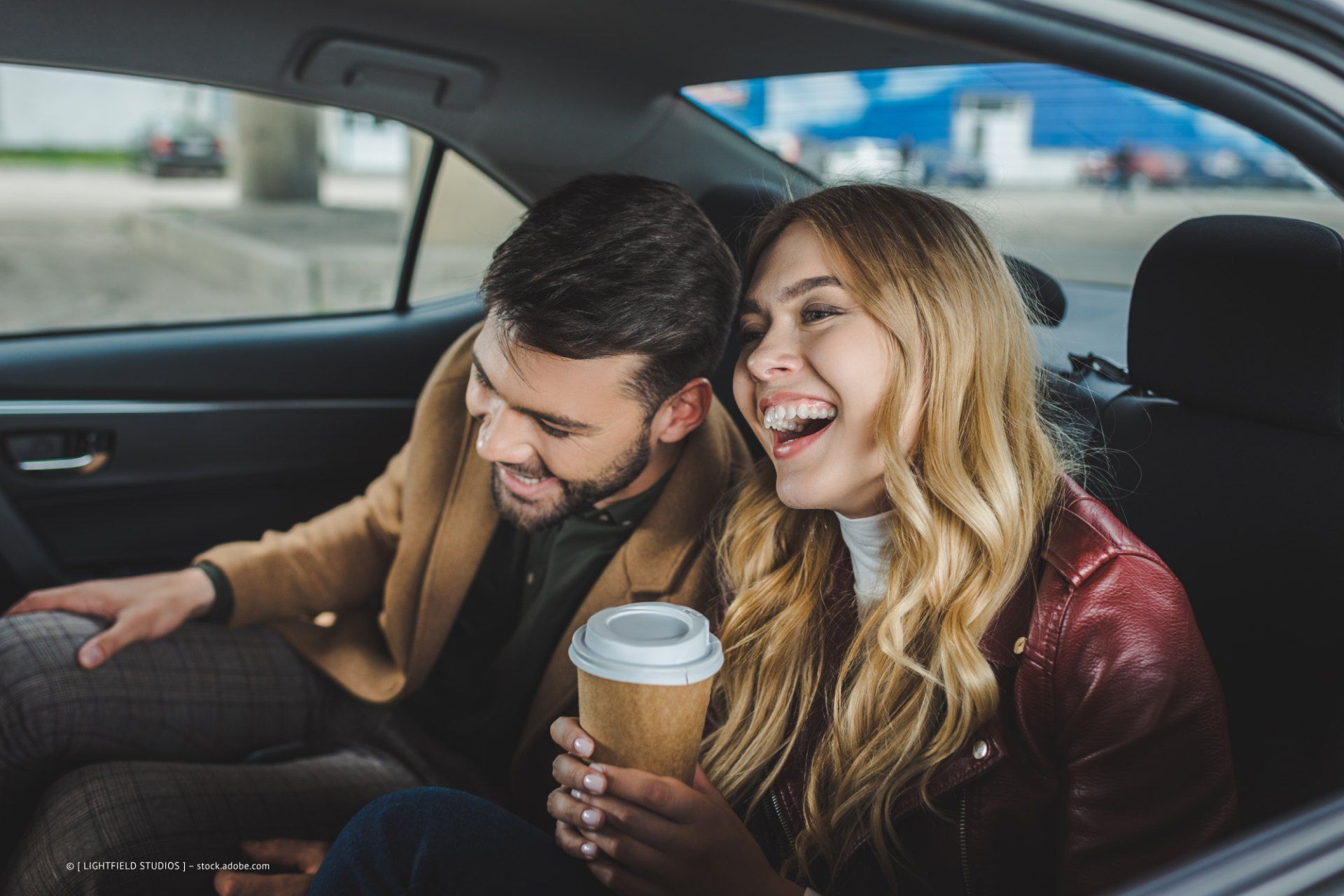 Mann und Frau lachen im Taxi
