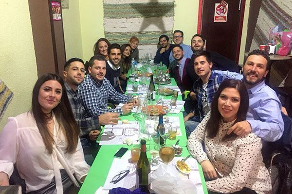 Un grupo de personas está sentado alrededor de una mesa larga.
