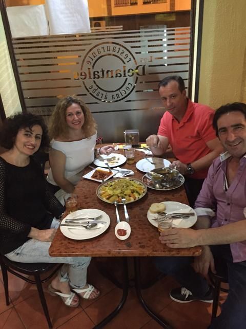 Un grupo de personas está sentado en una mesa con platos de comida.