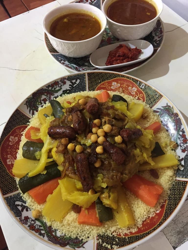 Un plato de comida con un tazón de sopa en una mesa.