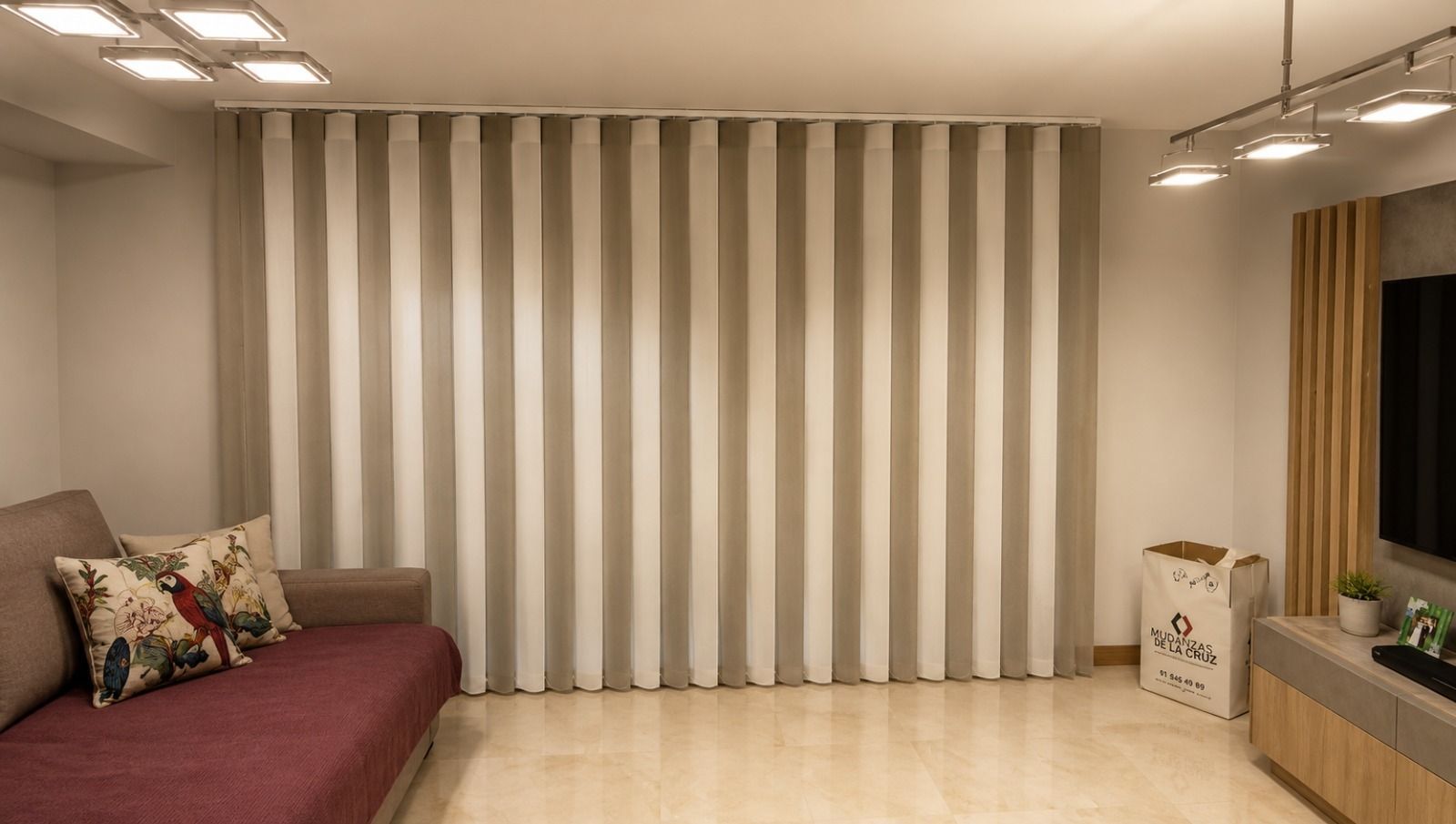 Sala de reuniones moderna con lámpara colgante negra, pared de cristal y sillas junto a una mesa de madera.
