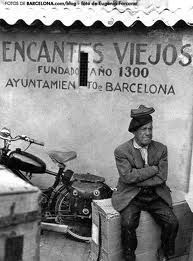 Un hombre está sentado en un banco frente a una motocicleta.