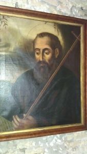 Un cuadro de un hombre con barba sosteniendo una cruz.