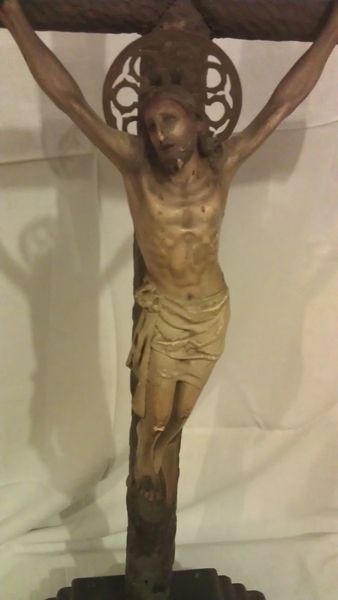 Una estatua de Jesús en una cruz con los brazos extendidos
