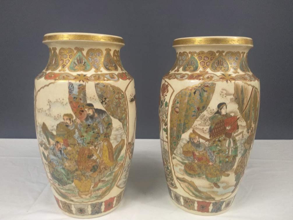 Dos jarrones con pinturas están sobre una mesa.