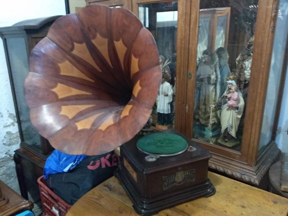 Un viejo fonógrafo está sobre una mesa de madera.