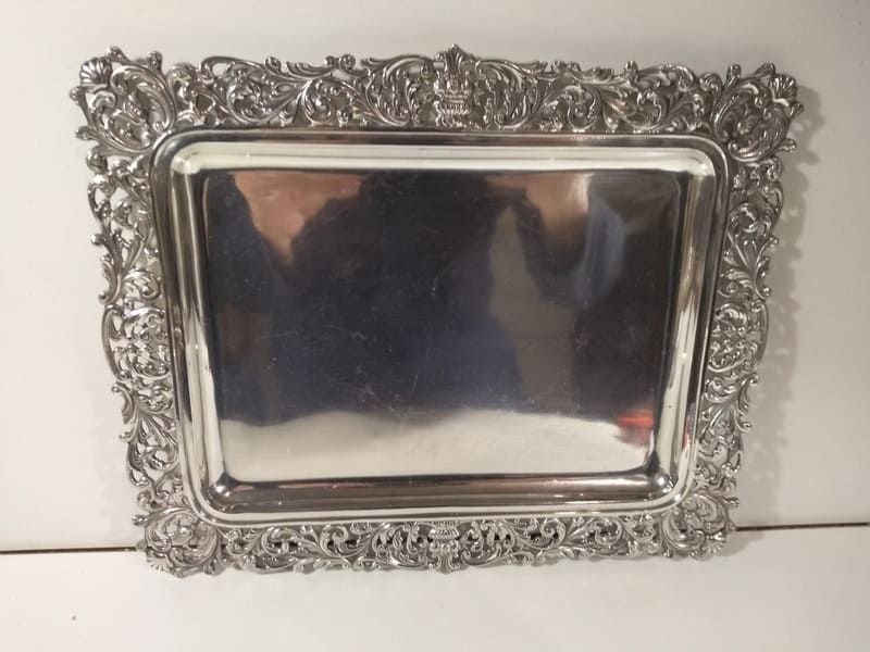 Una bandeja de plata con un marco de fotos encima