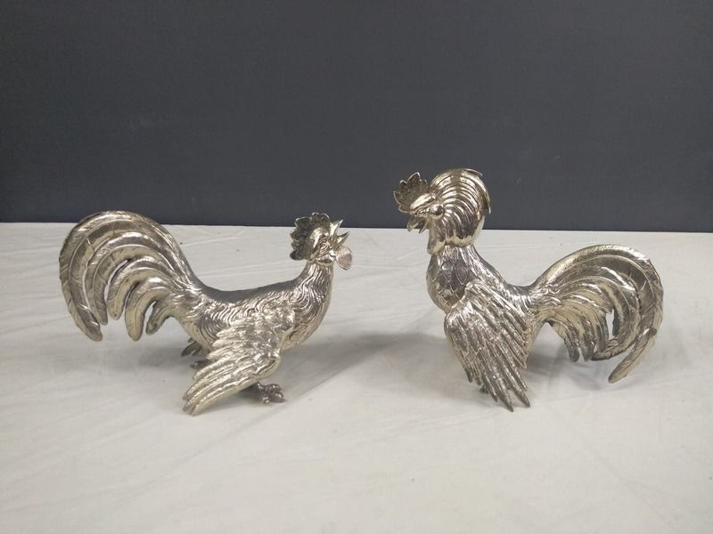 Dos gallos plateados están sentados uno al lado del otro en una mesa.