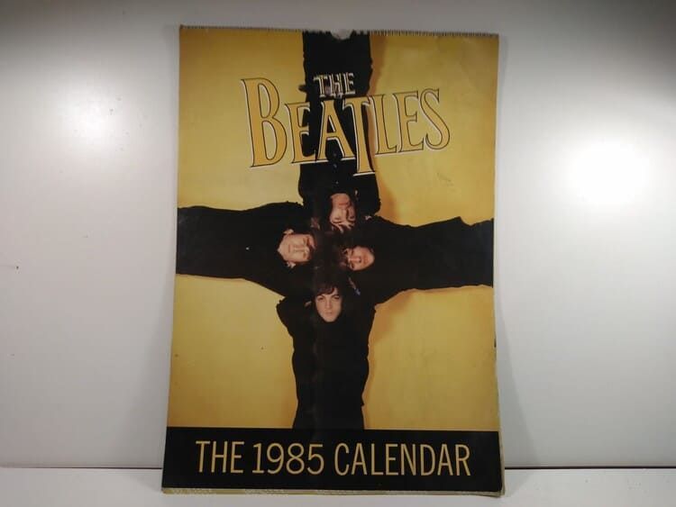 Un cartel de los Beatles con una cruz.