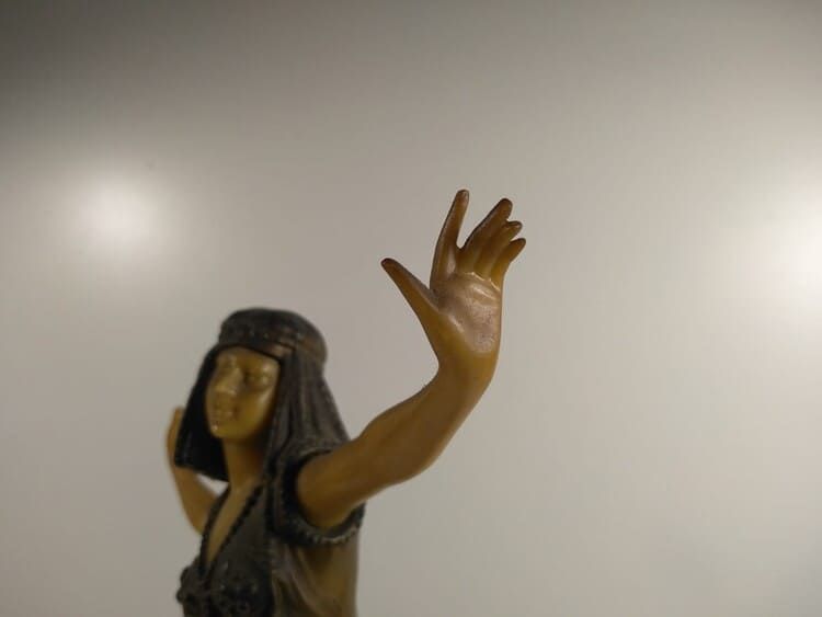 Una estatua de una mujer con el brazo extendido