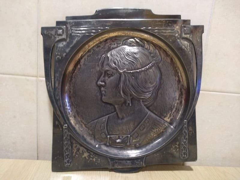 Una placa de metal con un retrato de una mujer en ella