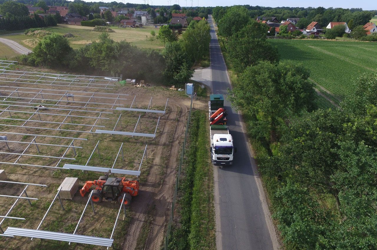 Eine Luftaufnahme eines LKWs, der eine Straße neben einem Feld entlangfährt.