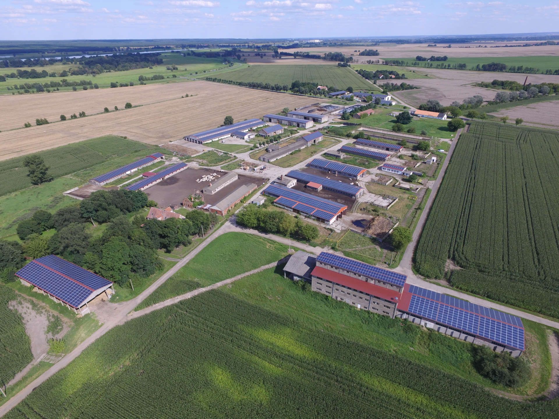 Eine Luftaufnahme einer Farm mit einer Aufdachanlage auf den Gebäuden.