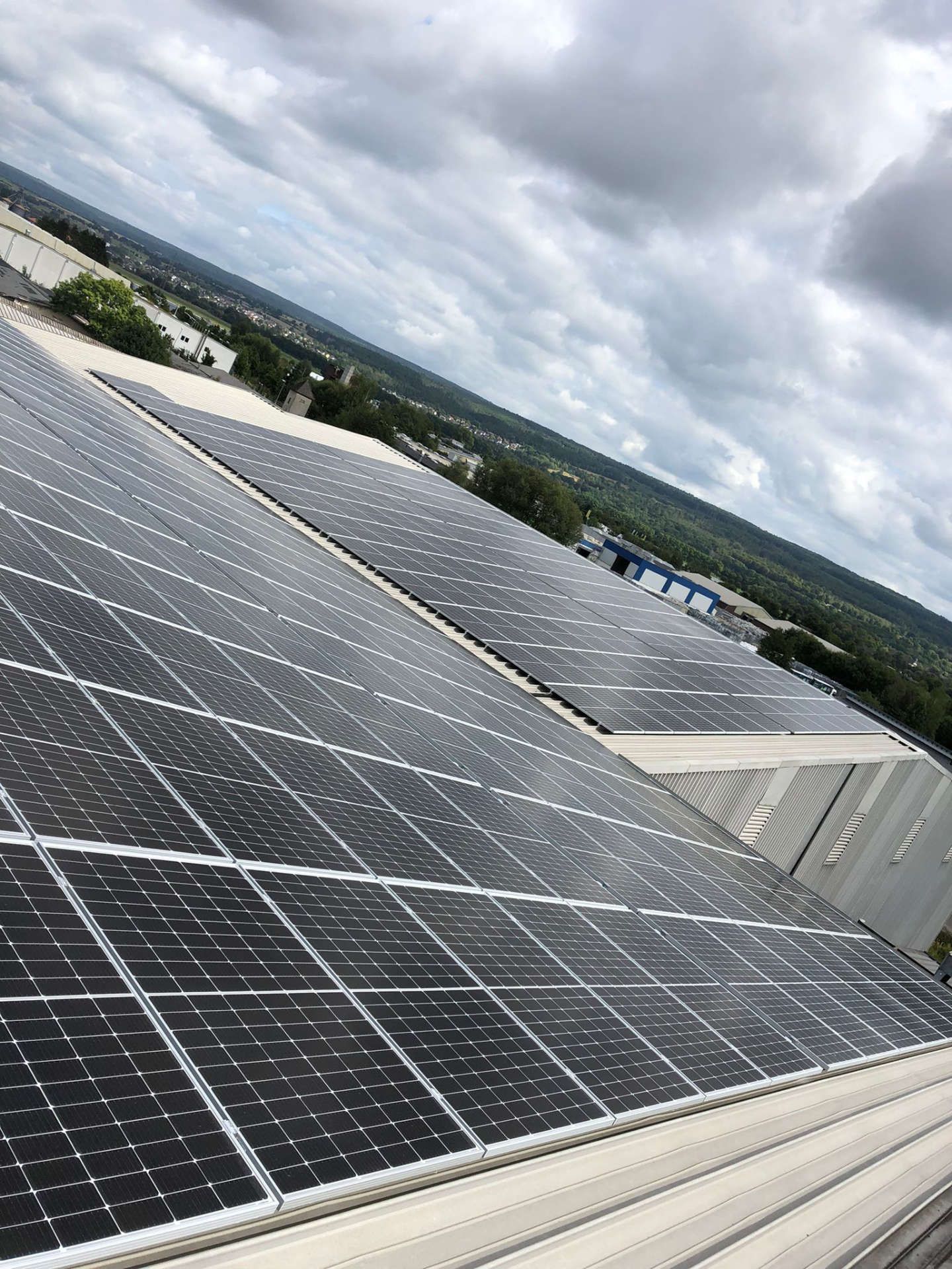 Auf dem Dach eines Gebäudes befinden sich viele Solarmodule.