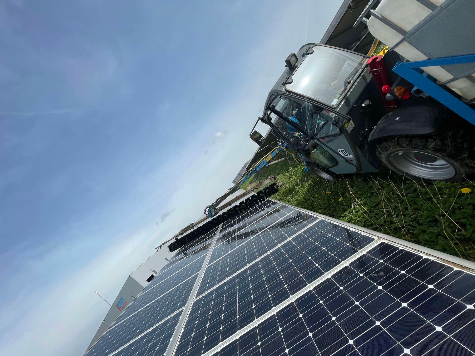 Ein LKW ist neben einer Reihe von Solarmodulen geparkt.