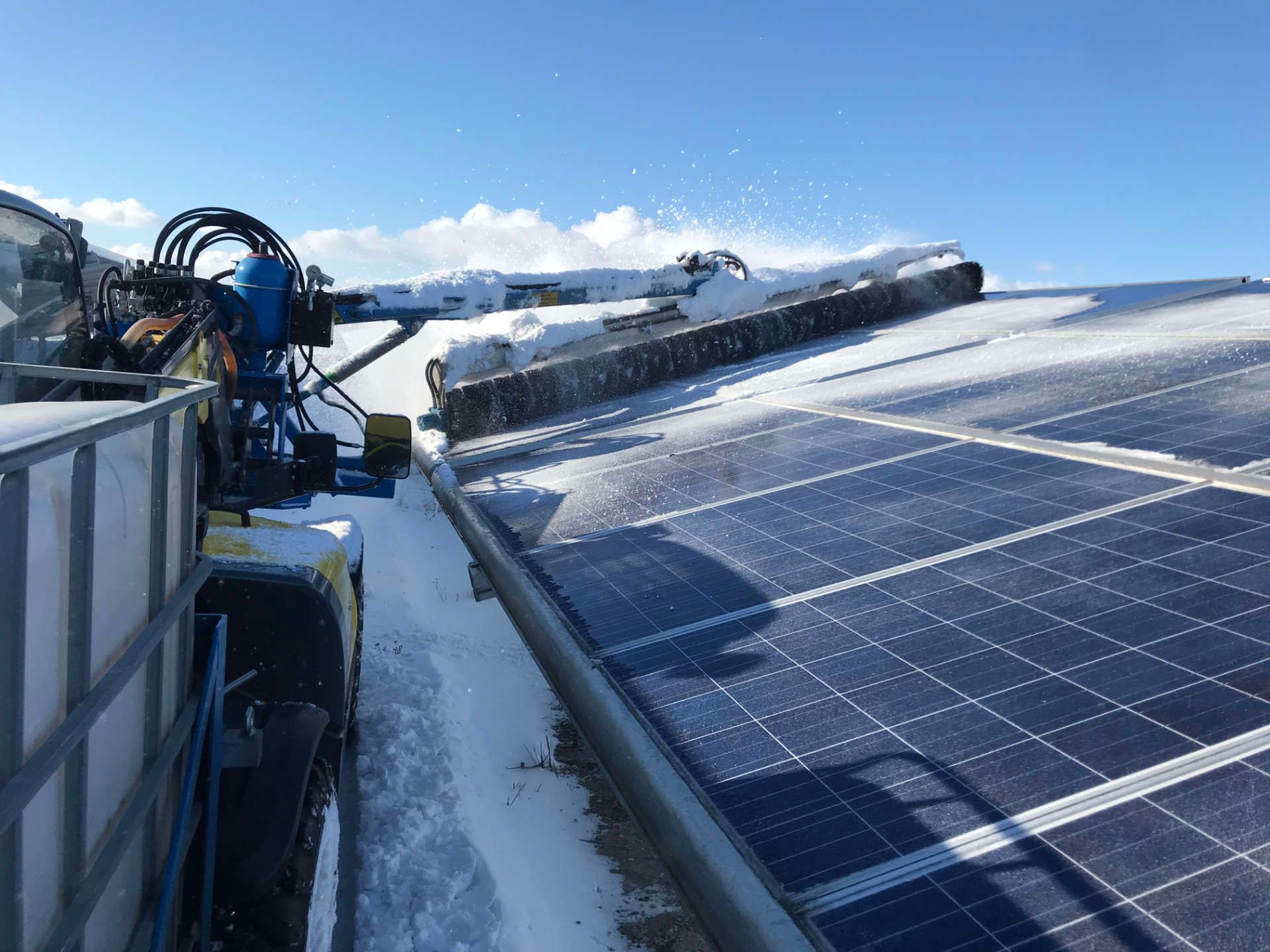 Eine Maschine reinigt Solarmodule im Schnee.