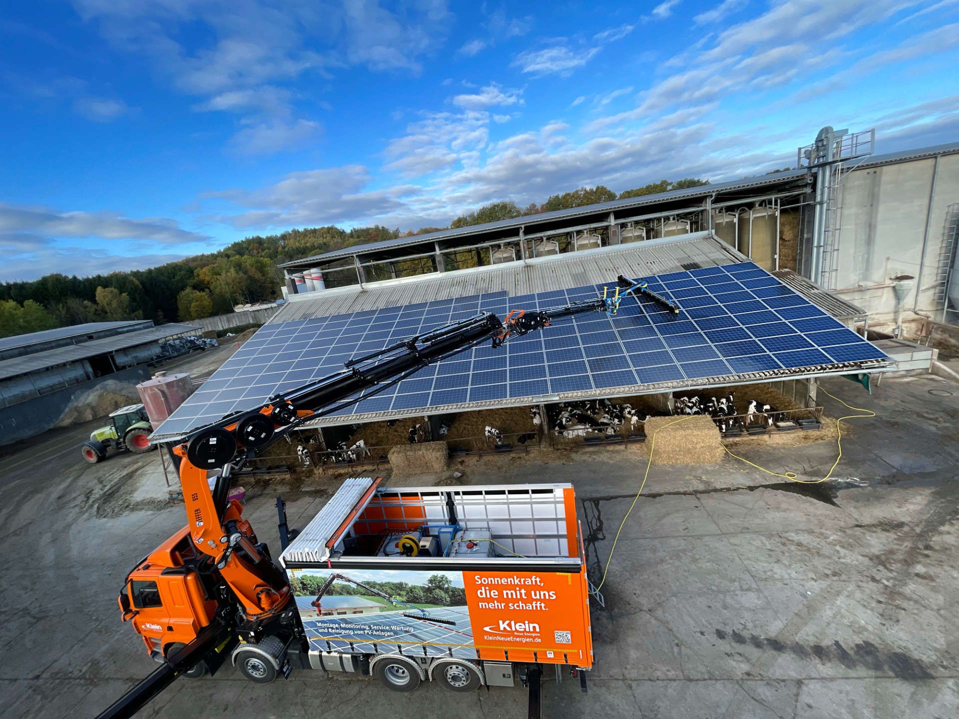 Ein LKW parkt vor einem Gebäude mit Solarzellen auf dem Dach.
