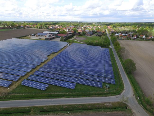 Eine Luftaufnahme einer Reihe von Solarmodulen auf einem Feld.