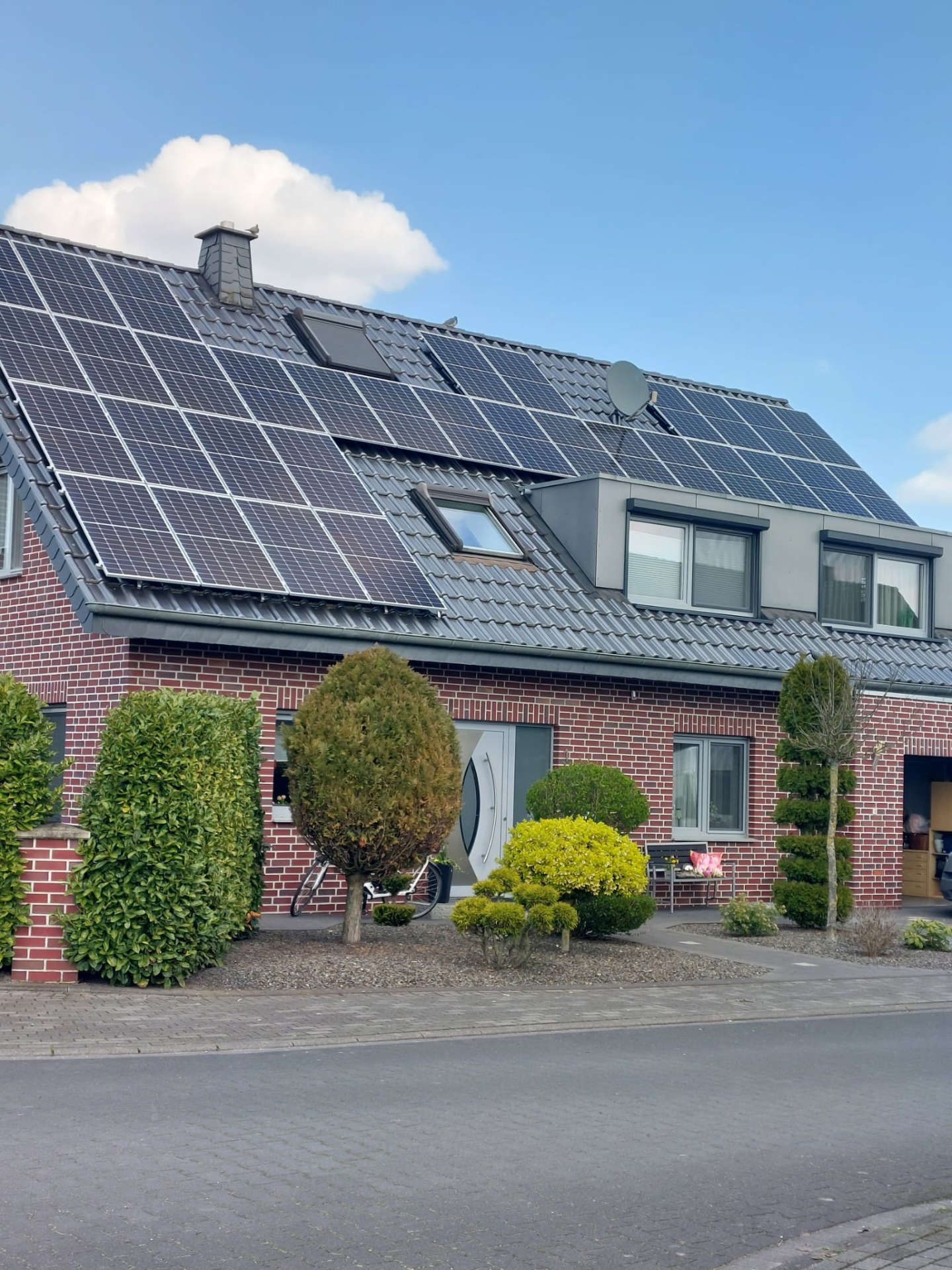 Ein Backsteinhaus mit Sonnenkollektoren auf dem Dach