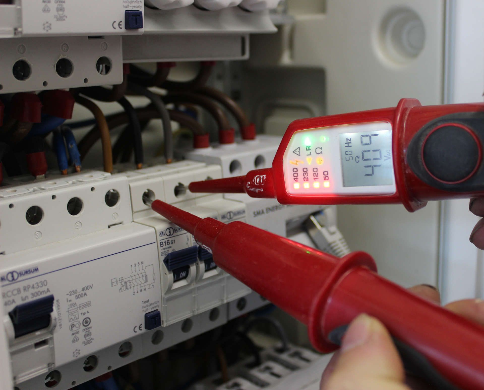 Eine Person überprüft mit einem Spannungsprüfer eine Leiterplatte