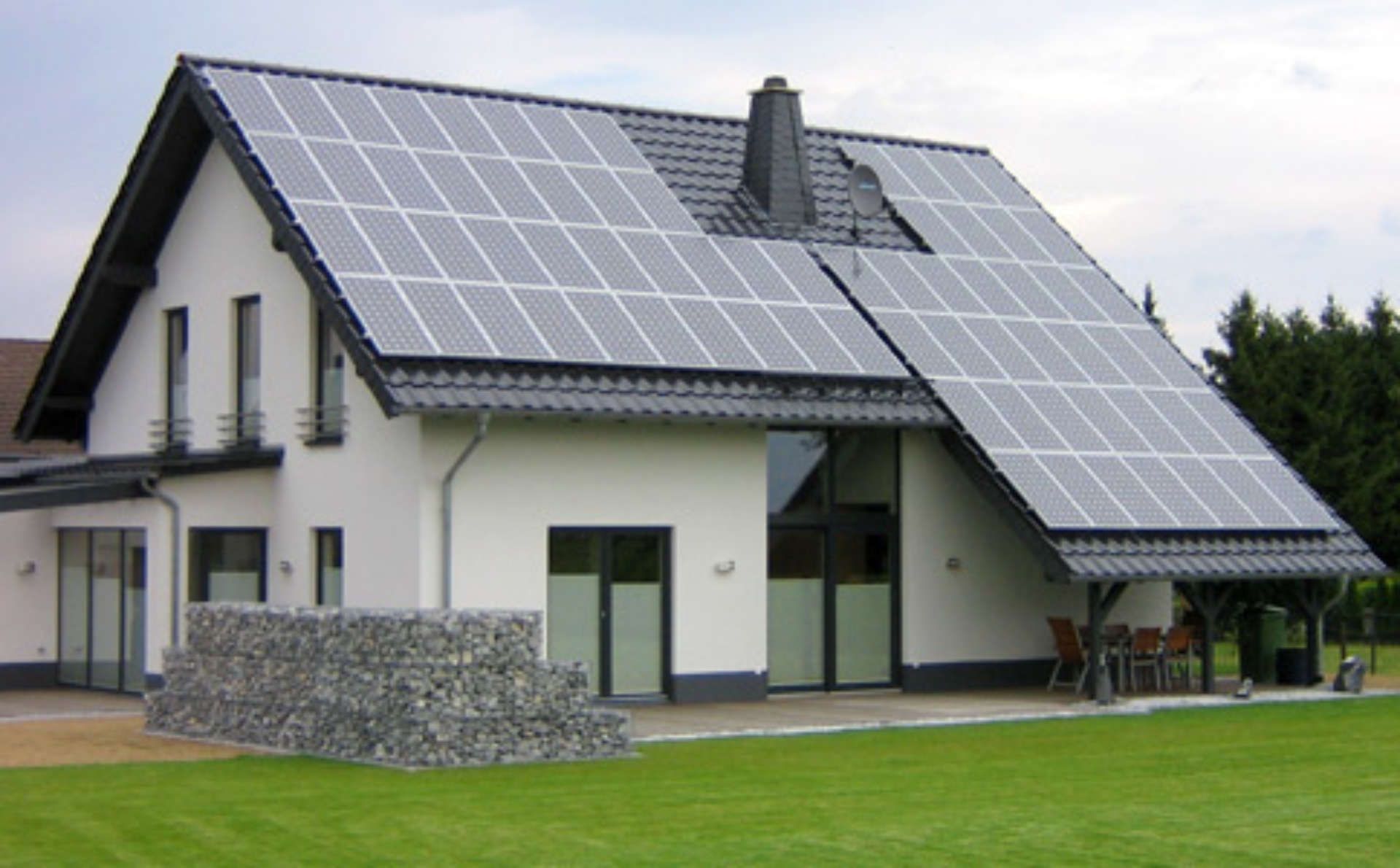 Ein weißes Haus mit Sonnenkollektoren auf dem Dach