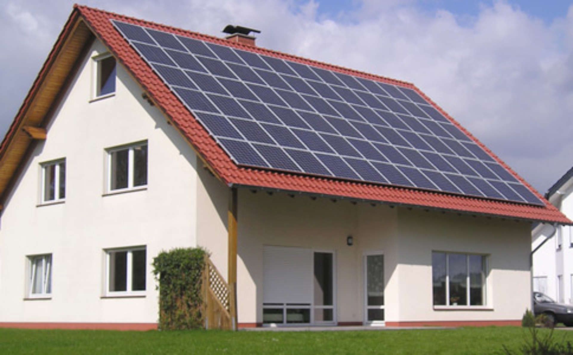 Ein weißes Haus mit einer Aufdachanlage auf dem Dach