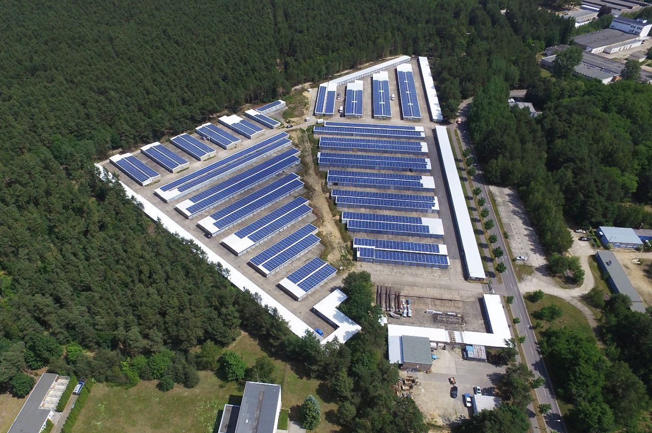 Eine Luftaufnahme einer großen Solarfarm mitten in einem Wald.