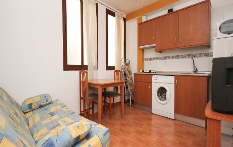 Una sala de estar con un sofá, una mesa y una lavadora.