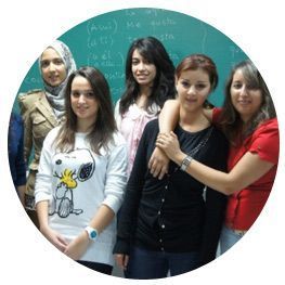 Un grupo de mujeres posa para una foto frente a una pizarra.