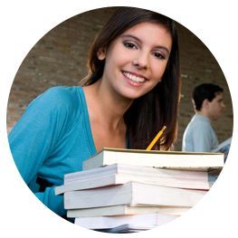 Una mujer sostiene una pila de libros y sonríe.