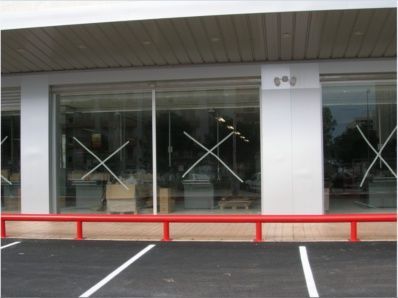 Un edificio con una barandilla roja delante.