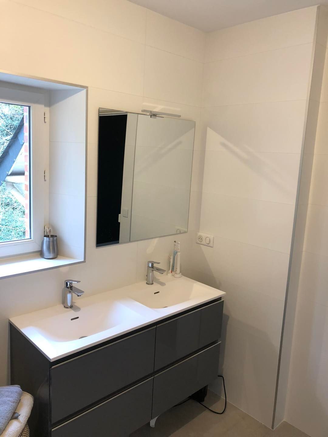 Salle de bains rénovée avec un meuble à double vasque.