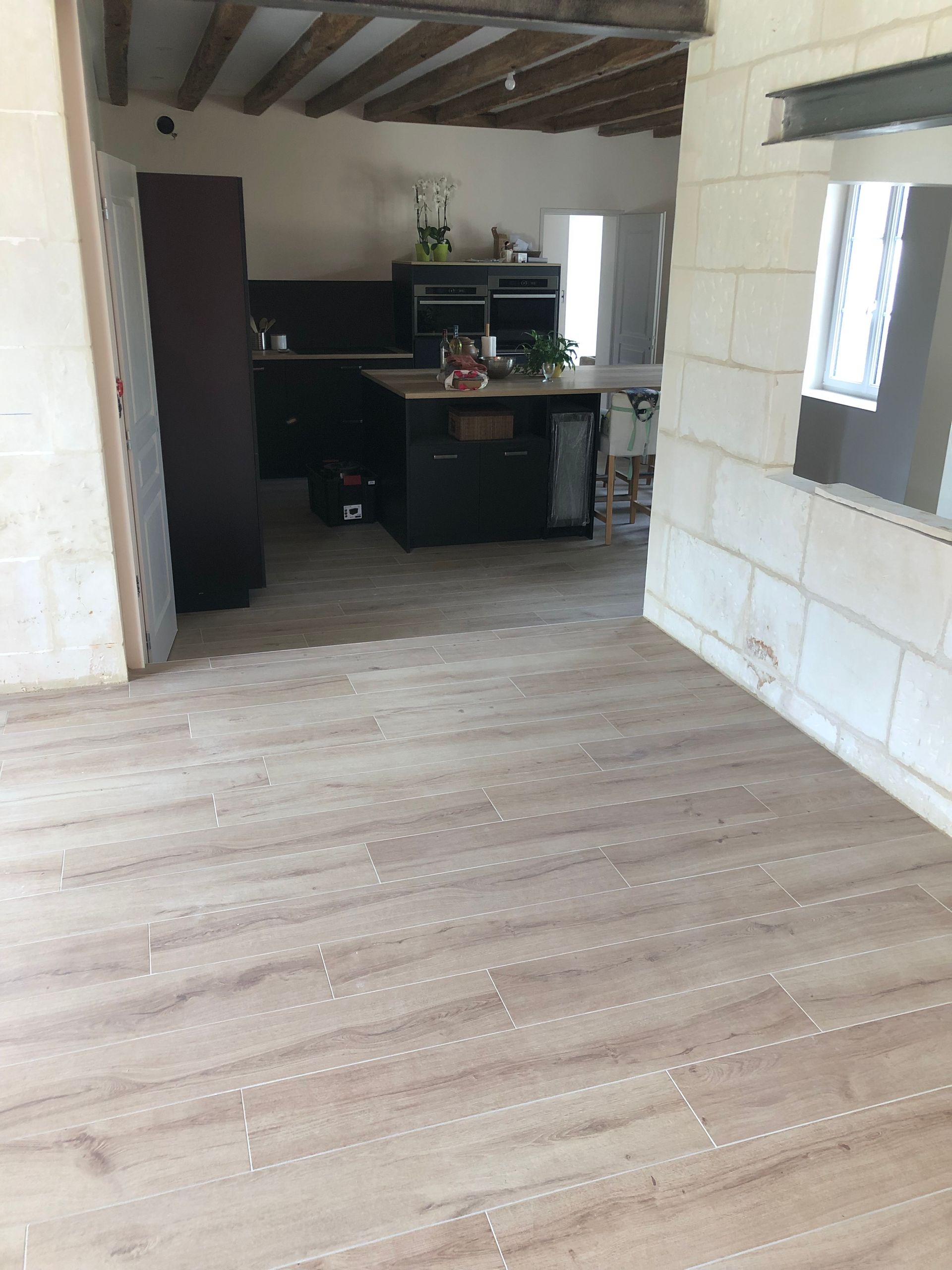 Carrelage beige dans une grande pièce à vivre.