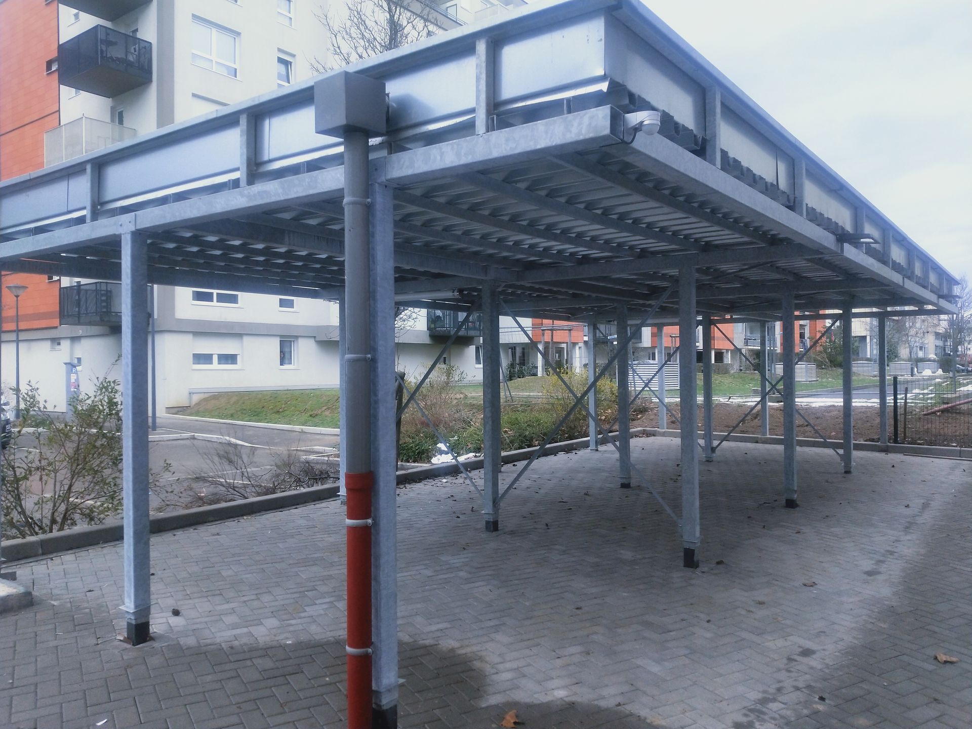 Escalier moderne en bois et blanc avec rampes en métal et panneaux muraux géométriques.