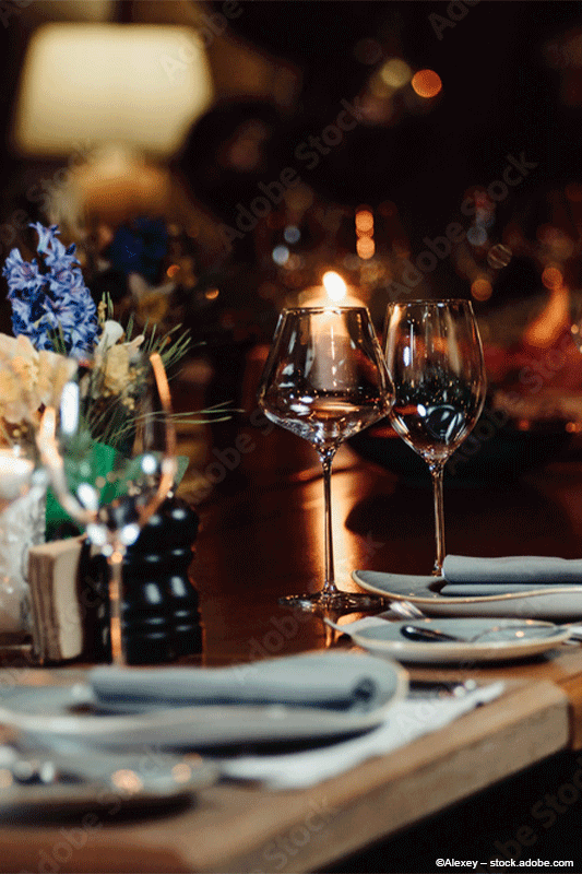 Ein für eine Dinnerparty gedeckter Tisch mit Weingläsern und Tellern.