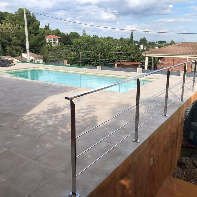 Una gran piscina con barandilla de acero inoxidable
