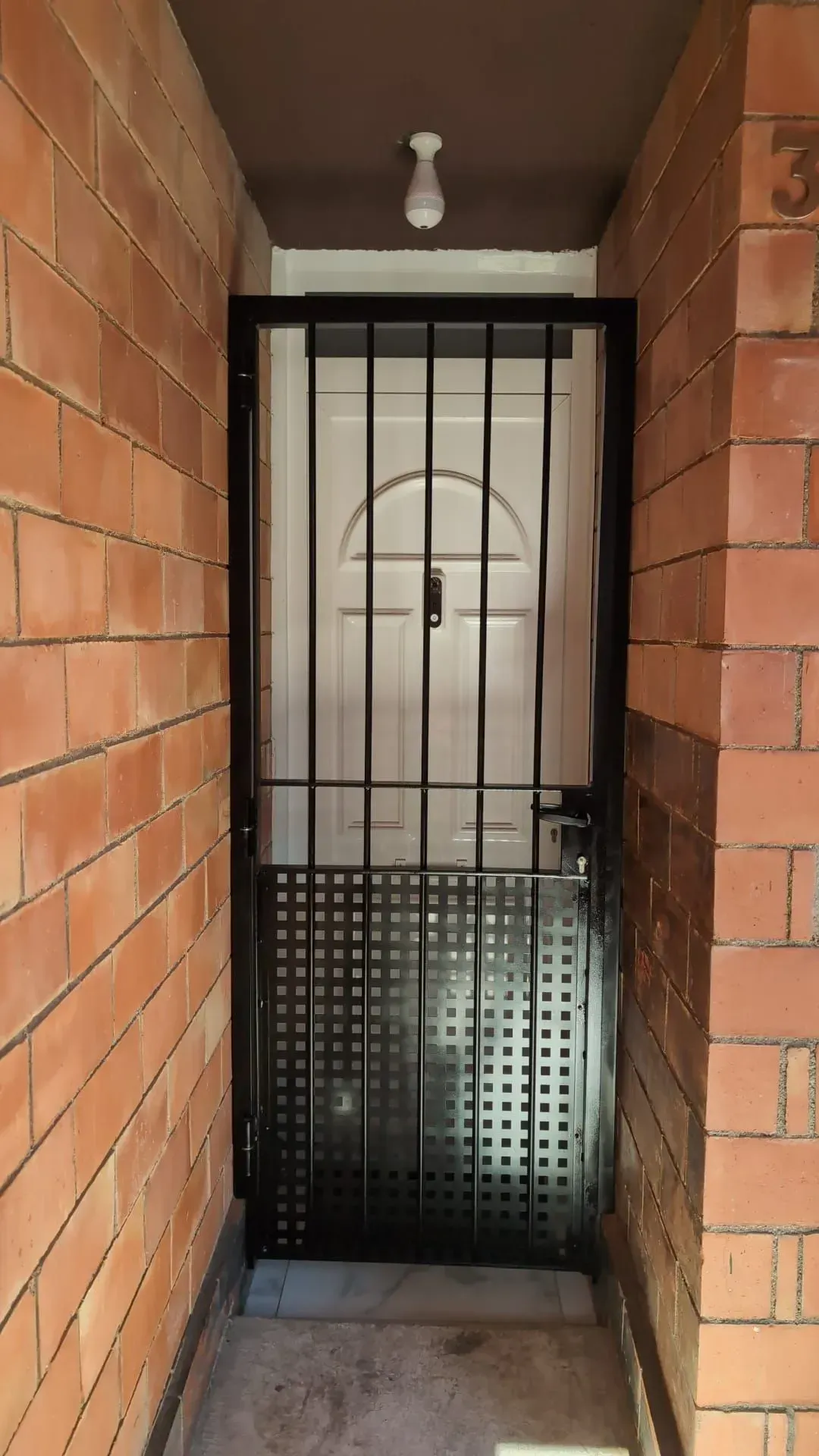 Una pared de ladrillos con una puerta en el medio.