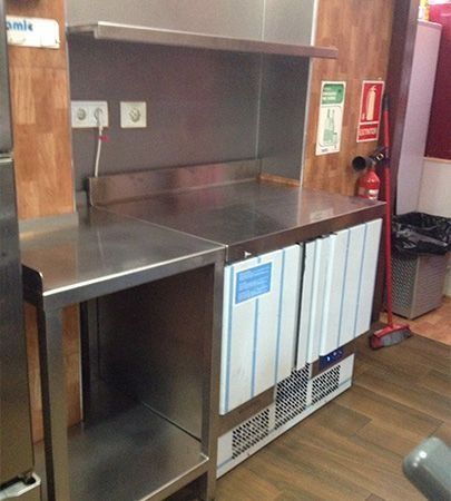 Una cocina con electrodomésticos de acero inoxidable y un extintor de incendios.