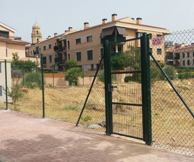 Una valla de alambre con una puerta delante de un edificio