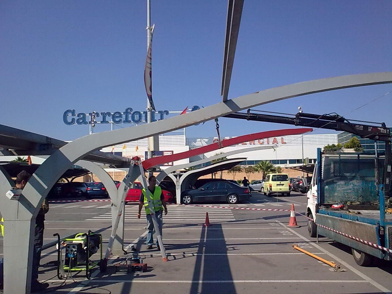 Se está construyendo un cartel de Carrefour en un estacionamiento.