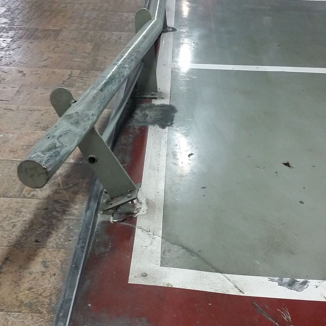 Una barandilla de metal al costado de un estacionamiento