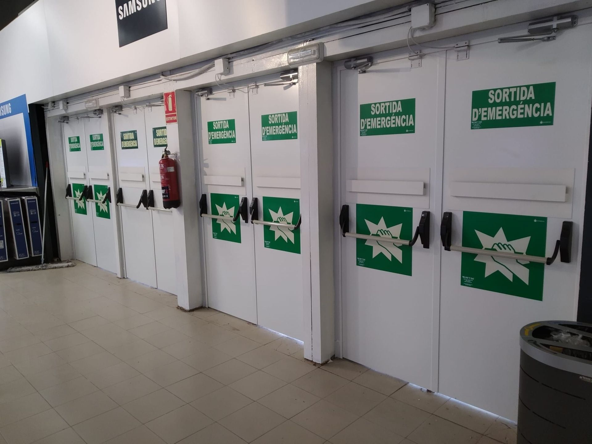 Una fila de puertas de salida de emergencia con pegatinas verdes.