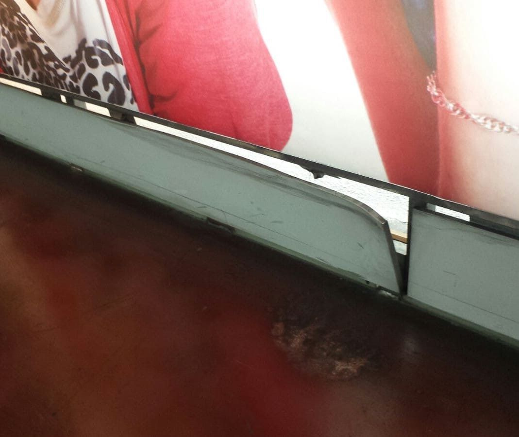 Una foto de una mujer con un suéter rojo está sobre una mesa de madera.