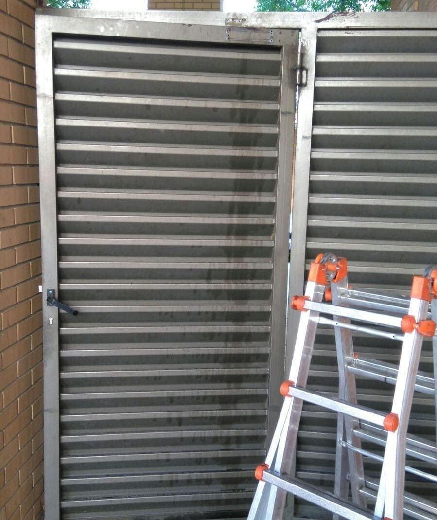 Una escalera está situada delante de una puerta de metal.