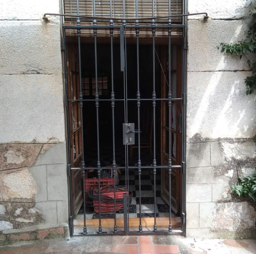 Una puerta con una verja de hierro forjado alrededor