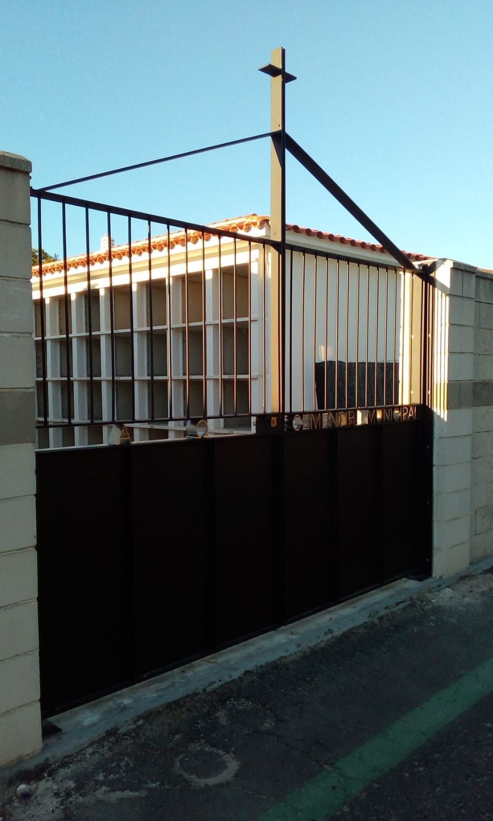 Una puerta negra con una cruz encima