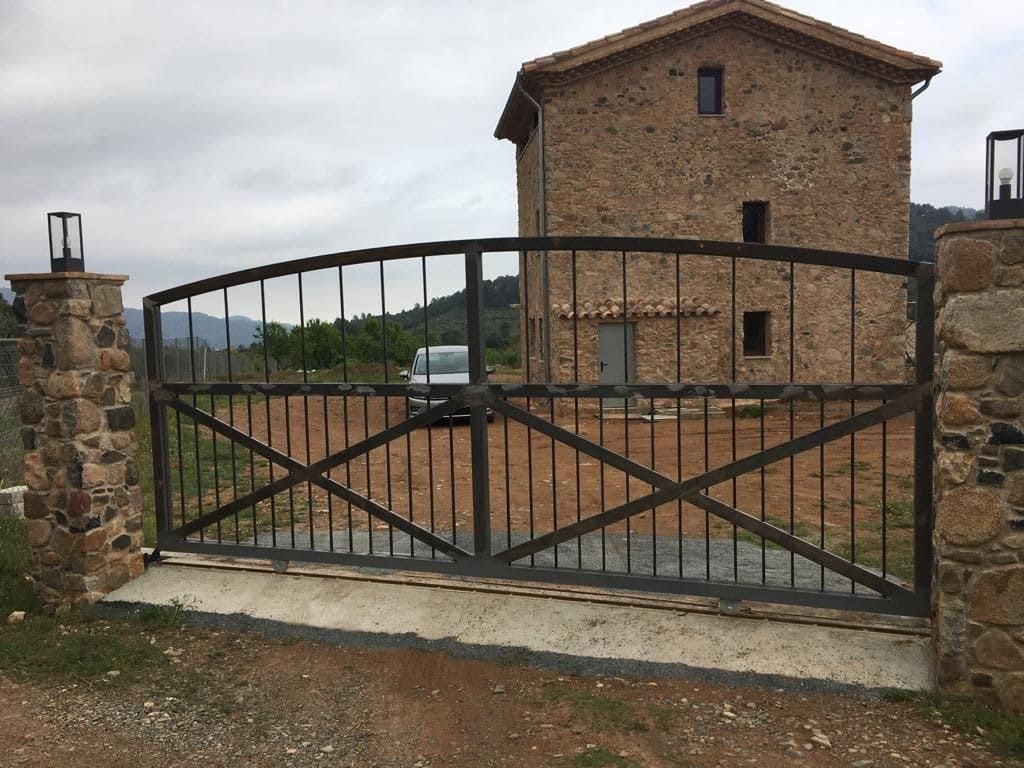 Un edificio de piedra con una puerta de metal delante.