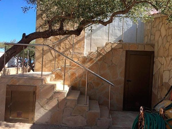 Un conjunto de escaleras que conducen a un edificio con un árbol al fondo.